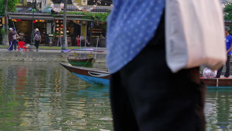 Tourist-taking-lantern-boat-ride-on-Hoai-river-in-Sampan-boat-in-ancient-town-of-Hoi-An-at-evening,-Vietnam