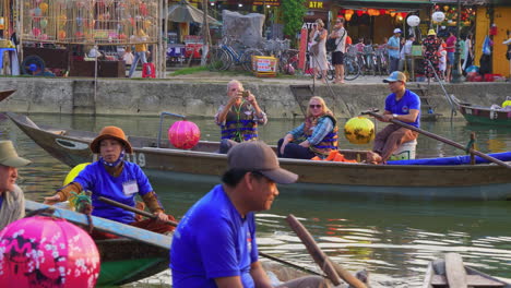 Tourist-taking-lantern-boat-ride-on-Hoai-river-in-Sampan-boat-in-ancient-town-of-Hoi-An-at-evening,-Vietnam