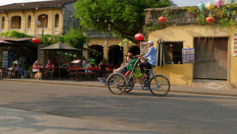 A-tracking-footage-of-a-tourist-riding-on-a-cyclo-rental-transportation-to-roam-around-the-City-of-Hoi-An-in-Vietnam
