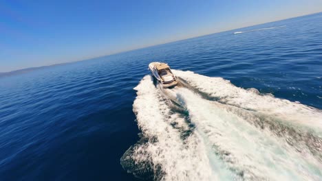 FPV-aerial-circling-a-yacht-sailing-off-the-coast-of-Spain-as-a-man-sunbathes-on-deck