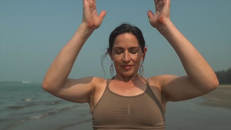 Namaste-brunette-woman-deep-breath-work,-meditating-yoga-at-beach-coast