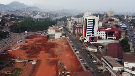 Drone-shot-of-a-construction-site-and-the-General-Delegation-Of-Taxes,-in-cloudy-Yaounde,-Cameroon