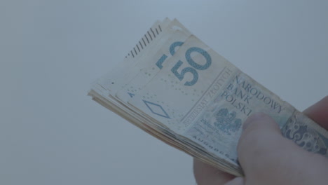 Man's-Hand-Holding-Polish-Zloty-Banknotes-of-50-100-200-bills