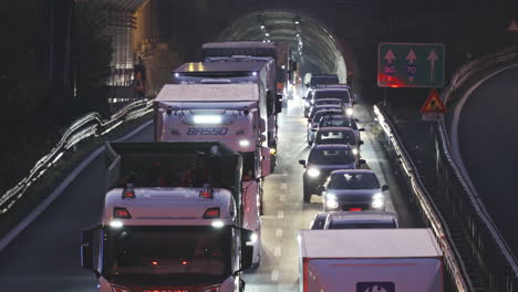 Heavy-traffic-highway-at-night,-cars-and-trucks-exiting-tunnel,-static