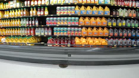 Slowly-passing-the-refrigerated-displays-of-fruit-juice-in-an-American-mega-grocery-store