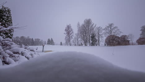 Timelapse-snow-pile-growing-in-a-snowy-rural-countryside-with-trees,-no-people