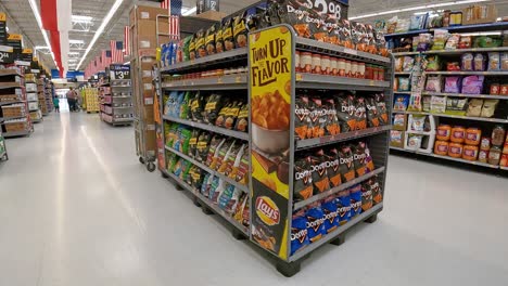 Slowly-walking-past-displays-of-chips-and-snacks-in-an-American-super-market