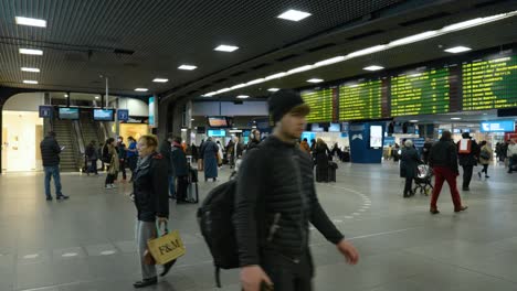 Pasajeros-Que-Caminan-Dentro-De-La-Estación-De-Tren-Sur-De-Bruselas-Con-Visualización-De-Horarios-En-Bruselas,-Bélgica