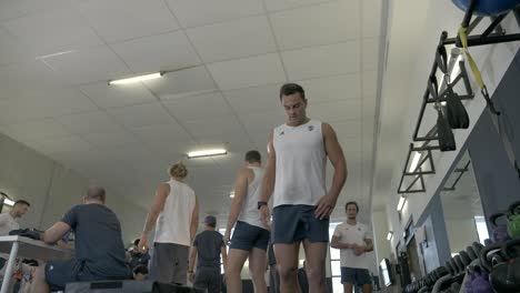 Slow-motion-shot-of-a-rugby-player-working-on-explosiveness-in-the-gym-with-teammates