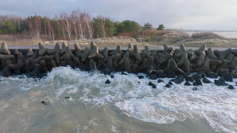 Aerial-establishing-view-of-Port-of-Liepaja-concrete-pier,-Baltic-sea-coastline-day,-big-waves-splashing,-slow-motion-drone-dolly-shot-moving-right