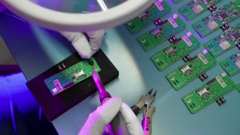 Close-up-of-a-person-soldering-elements-of-a-base-plate-of-an-electronic-device