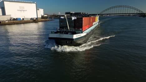 Aerial-of-a-fast-moving-containership-in-the-dutch-noord-canal-in-Alblasserdam,-The-Netherlands