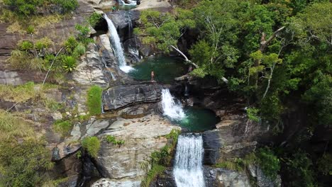 Tourists-Cliff-Jumping-at-Diyaluma-Falls-Waterfall-in-Sri-Lanka,-Aerial-View