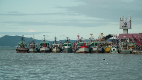 Row-of-Fisherman's-Boats-Docked-by-the-Sabah-Fish-Marketing-Sdn-Bhd-Harbor-in-Kota-Kinabalu-Bay,-Malaysia