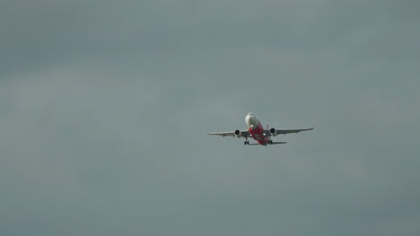 Air-Asia-Commercial-Airplane-Flying-in-the-Sky-With-Grey-Clouds-In-Background