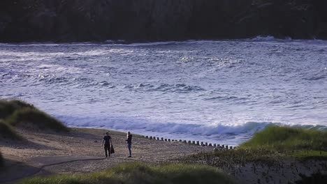 Golden-hour-footage-of-a-couple-walking-along-Dalmore-beach-near-Carloway
