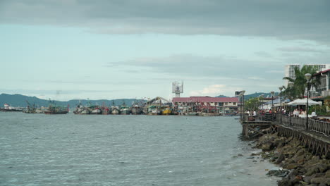Establishing-view-of-Todak-Waterfront-and-SAFMA-Fishing-Market-with-Trawler-Boats-Docked-in-Harbor