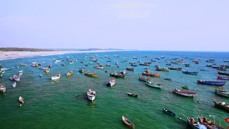 traditional-flouting-fisher-boat-in-the-Indian-Ocean,-the-camera-zooms-out,-aerial-drone-scene,-blue-flag-beach-in-India