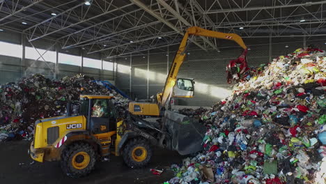 Bulldozer-And-Grab-Crane-Working-Inside-Giant-Facility-Sorting-Trash-Waste