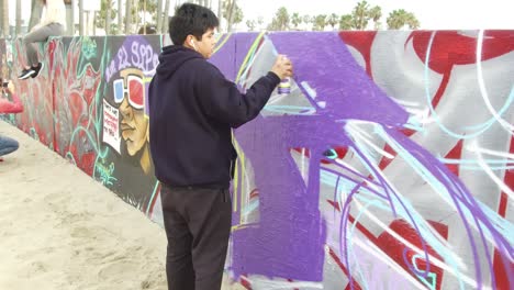 Gente-Pintando-Con-Spray-Una-Pared-De-Arte-En-La-Playa