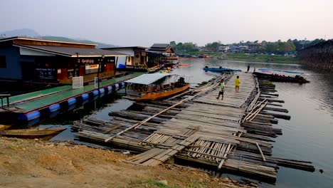 Floating-homes-and-bamboo-pathways,-Thai-boats-and-people