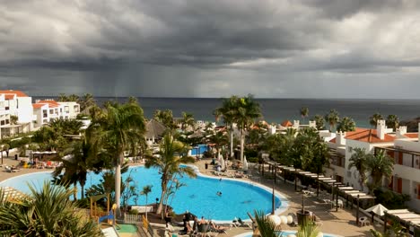 Schwerer-Tropischer-Regensturm-über-Dem-Atlantischen-Ozean.-Zeitraffer-Eines-Resorts-Mit-Swimmingpool