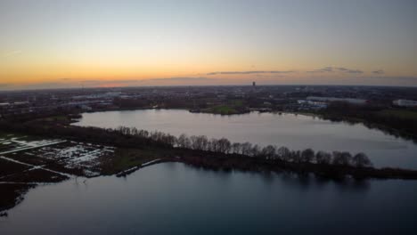 Beautiful-lake-on-city-side-during-sunset-time,-aerial-hyper-lapse