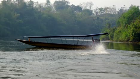 Thai-boats-running-with-the-motor-engine-on-the-water-with-the-driver-and-air-smoke-polluted-environment