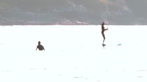Ein-Surfer-Und-Paddle-Boarder-Draußen-Im-Meer-In-Tofino,-Britisch-Kolumbien