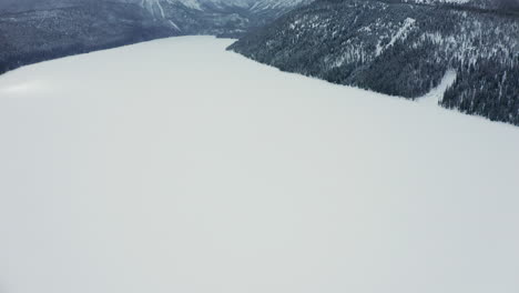 Panorámica-Sobre-El-Lago-De-Gallineta-Nórdica-Congelada-Hasta-Las-Montañas-De-Diente-De-Sierra-De-Idaho-En-Invierno