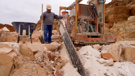 Stone-Chainsaw-machine-cutting-blocks-of-limestone-at-a-quarry-with-operator,-Medium-shot