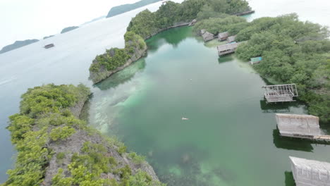 FPV-drone-dives-and-flies-over-paradise-lagoon-in-Raja-Ampat,-Indonesia