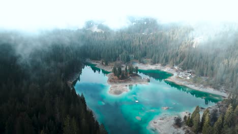 Aerial-view-of-a-pristine-blue-water-lake-Caumasee-with-forests-and-cloudsaround-in-Switzerland
