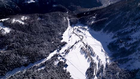 Vista-Aérea-Del-Paisaje-Cubierto-De-Nieve-Con-Bosques,-Colinas-Y-Ríos-En-Un-Soleado-Día-De-Invierno-En-Alp-Grum,-Suiza