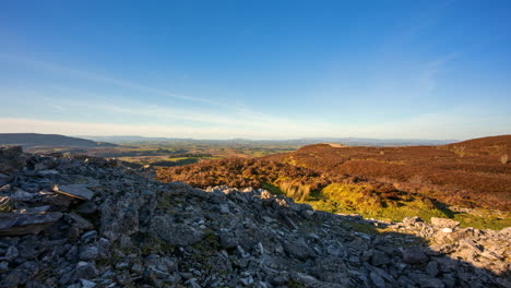 Panorama-motion-timelapse-of-rural-nature-landscape-with-ruins-of-prehistoric-passage-tomb-stone-blocks-in-the-foreground-during-sunny-day-viewed-from-Carrowkeel-in-county-Sligo-in-Ireland
