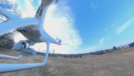 Close-up-Side-View-of-Dji-Phantom-4-Quadcopter-Drone-Flying-Over-Fields