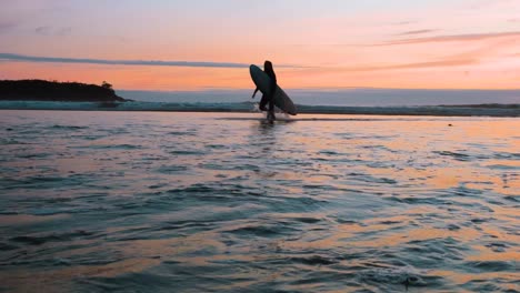 Ein-Surfer-Verlässt-Das-Wasser-Bei-Sonnenuntergang-In-Tofino,-Britisch-Kolumbien