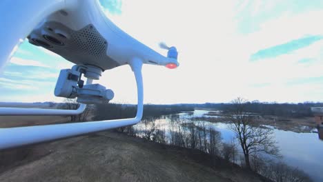Nahaufnahme-Der-DJI-Phantom-4-Quadrocopter-Drohne,-Die-Vorwärts-In-Richtung-Des-Gewundenen-Flusses-Fliegt