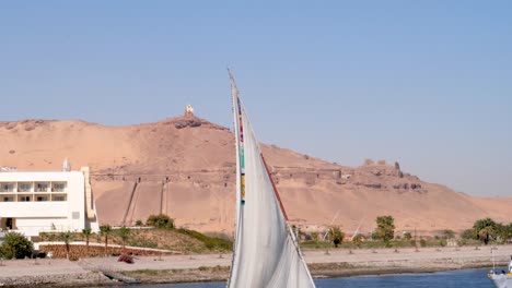 Detail-Eines-Felukenauslegers-Mit-Einem-Sandigen-Hügel-Im-Hintergrund,-Assuan,-Ägypten