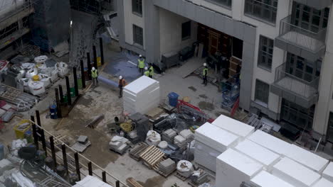 Construction-Workers-Moving-Material-On-Floor-At-9-Millbank-Building-Site