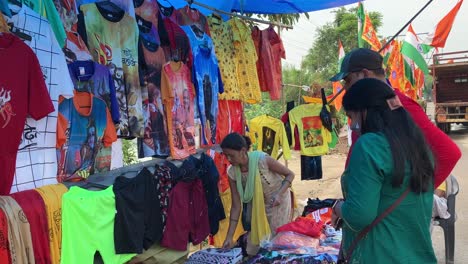 Eine-Ladenbesitzerin-Nimmt-Kleidung-Mit-Lord-Shiva-Aufdrucken-Ab,-Um-Sie-An-Pilger-Zu-Verkaufen