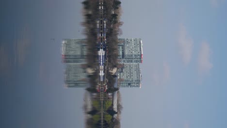 Vertikale-Aufnahme-Von-Bürogebäuden-Und-Deren-Spiegelung-Auf-Dem-Wasser