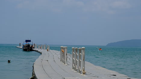 Plastic-container-floating-dock-with-blue-ocean-and-Thailand-boat