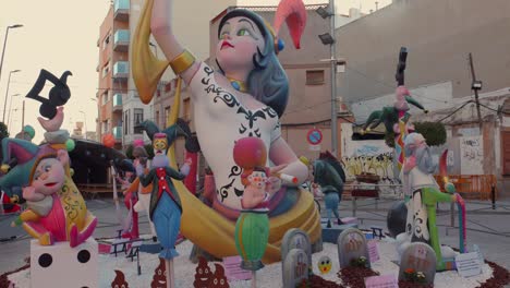 Tilt-down-shot-of-fallas-figures-from-Valencian-community-on-displayed-along-roadside-in-Benicarlo,-Spain-at-daytime
