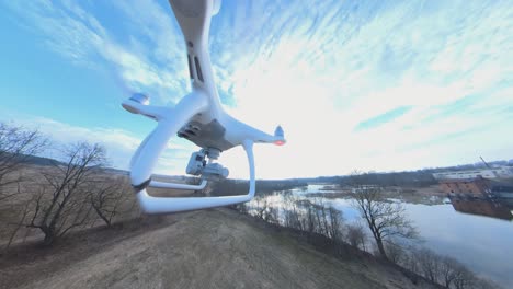 Seitenansicht-Der-DJI-Phantom-Quadcopter-Drohne,-Die-Vorwärts-In-Richtung-Des-Gewundenen-Flusses-Fliegt