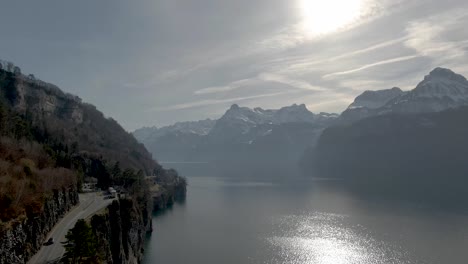 Drone-shot-over-swiss-road-at-beautiful-lake