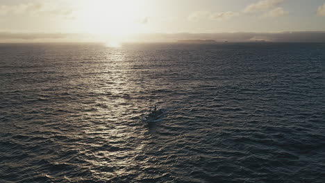 Luftaufnahme-Eines-Fischerbootes,-Das-Nach-Einem-Langen-Tag-Am-Meer-Wieder-An-Land-Zurückkehrt,-Mit-Berlengas-Insel-Am-Meer