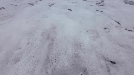man-walking-on-black-sand-beach-india-mumbai-vasi-rajodi-beach