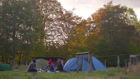 Drei-Camperinnen-Sitzen-An-Einem-Herbstnachmittag-In-Skandinavien-Vor-Ihrem-Zelt