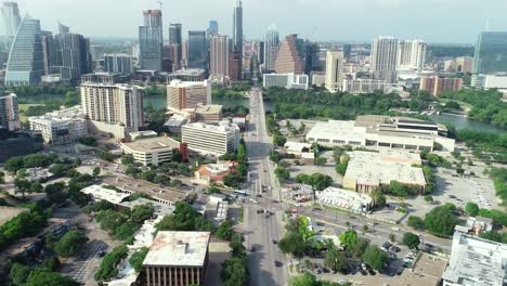 Aerial-drone-footage-of-Austin,-Texas,-South-Congress-bridge-traffic-with-the-capital-building-in-view-at-the-top